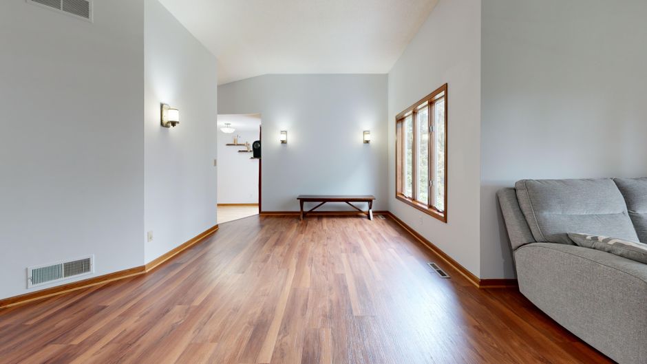 Bright minimalist living room with wooden floors and modern decor.